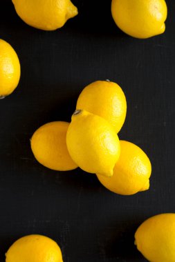 Siyah arka planda olgun sarı organik limonlar, üst manzara. Dümdüz, tepeden, yukarıdan. 
