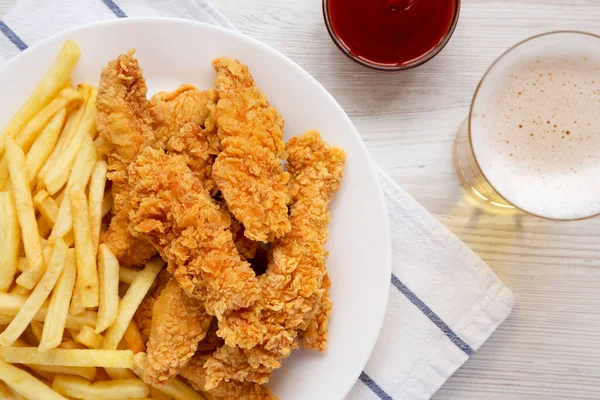 Ev yapımı Çıtır Tavuk Tenceresi ve soslu patates kızartması ve bir bardak soğuk bira, yukarıdan manzara. Üst görünüm, genel görünüm, düz görünüm.