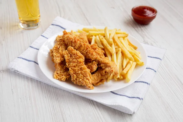 Ev yapımı çıtır tavuk ve soslu patates kızartması ve bir bardak soğuk bira.. 