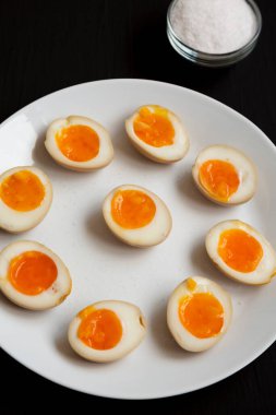 Ev yapımı Unami Soya Sosu. Beyaz bir tabakta, siyah bir yüzey üzerinde.. 