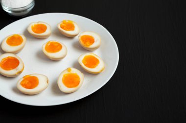 Siyah arka planda beyaz bir tabakta ev yapımı Unami Soya Sosu Yumurtası. Boşluğu kopyala.