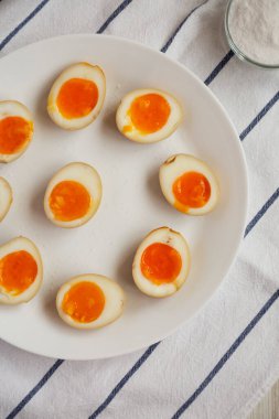 Beyaz tabakta ev yapımı Unami Soya Sosu Yumurtası, üst manzara. Yukarıdan, dümdüz uzanmış. 