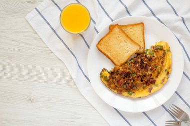 Ev yapımı Denver omleti, beyaz bir tabakta, üst manzara. Dümdüz, tepeden, yukarıdan. Boşluğu kopyala.