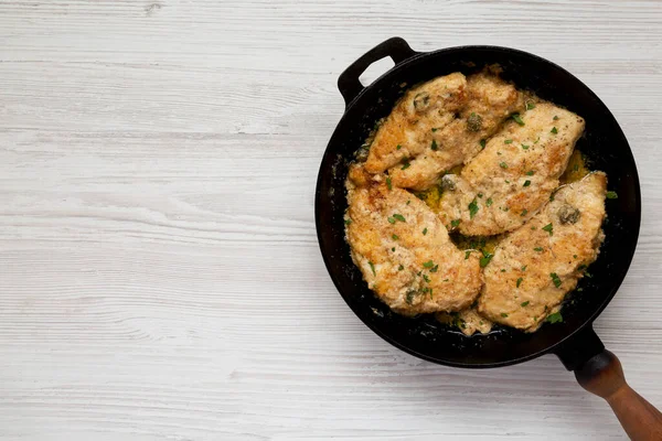 Ev yapımı İtalyan Tavuğu Piccata, dökme demir tavada, üst manzara. Yukarıdan, dümdüz yatıyordu. Boşluğu kopyala.