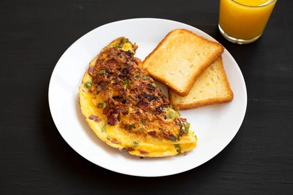 Siyah arka planda beyaz bir tabakta ev yapımı Denver omleti, düşük açılı..