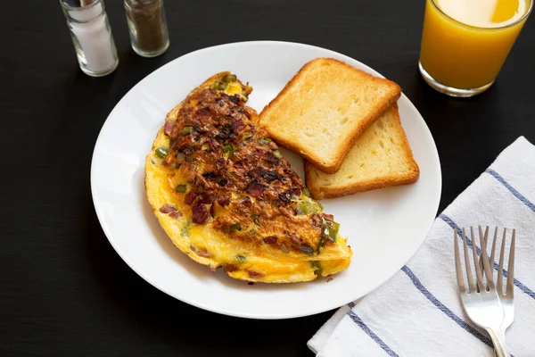 Siyah arka planda beyaz bir tabakta ev yapımı Denver omleti, düşük açılı.. 