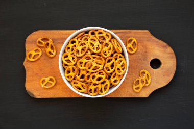 Gri bir kasede çıtır kraker, siyah bir yüzey, üst manzara. Dümdüz, tepeden, yukarıdan. 