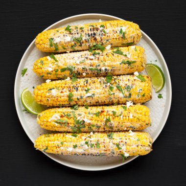 Ev yapımı Meksika sokak mısırı, siyah arka planda bir plaka, üst manzara. Dümdüz, tepeden, yukarıdan. 