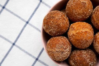 Ev yapımı kızarmış donut delikleri. Pembe bir klozetin içinde, üst tarafta. Dümdüz, tepeden, yukarıdan. Boşluğu kopyala.