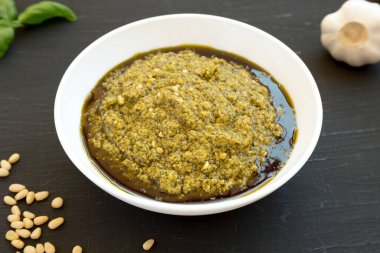 Siyah arka planda parmesanlı ve çam fıstıklı ev yapımı Basil Pesto.. 