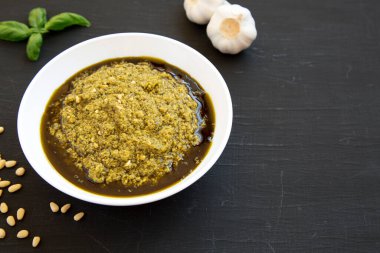 Siyah arka planda parmesanlı ve çam fıstıklı ev yapımı Basil Pesto. Boşluğu kopyala.
