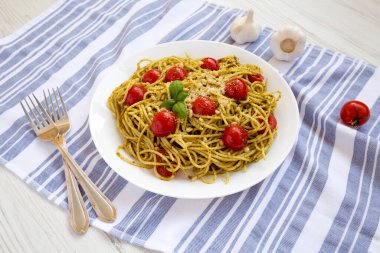 Beyaz tabakta domatesli ve çam fıstıklı ev yapımı Pesto Makarnası.. 