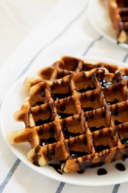 Beyaz bir tepside beyaz bir tabakta nefis ev yapımı Belçika şekerli waffle 'ları, düşük açılı. Yakın plan..
