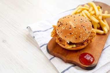 Ev yapımı patates kızartmalı tavuk burgeri ve köy panosunda ekşi tatlı sosu. Metin için boşluk.