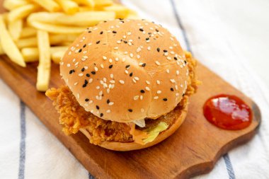 Ev yapımı patates kızartmalı tavuk burgeri ve köy panosunda ekşi tatlı sosu. Düşük açılı.. 