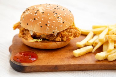 Ev yapımı patates kızartmalı tavuk burgeri ve köy panosunda ekşi tatlı sosu. Yakın plan..