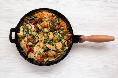 Ev yapımı Kremalı Toskana Tavuğu, dökme demir tavada, üst manzara. Dümdüz, tepeden, yukarıdan.