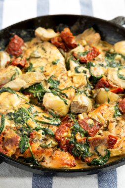 Ev yapımı Kremalı Toskana tavuğu dökme demir tavada, düşük açılı. Yakın plan..