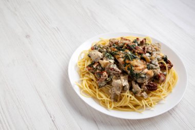 Beyaz tabakta makarna ile ev yapımı kremalı Toskana tavuğu. Boşluğu kopyala.