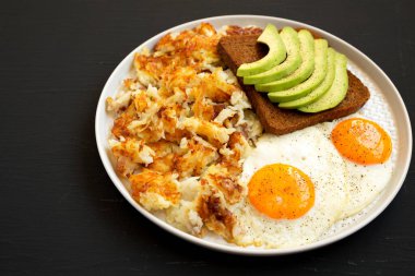 Lezzetli ev yapımı kızarmış et ve siyah bir tabakta yumurta, yan manzara. Boşluğu kopyala.