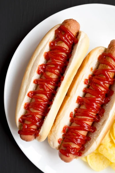 Вкусный Американский Hot Dog Картофельными Чипсами Белой Тарелке Черном Фоне — стоковое фото