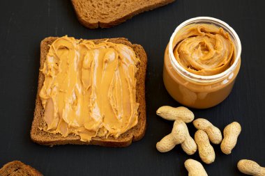 Siyah bir yüzey üzerinde Fıstık Ezmeli Ekmek, düşük açılı görünüm. 