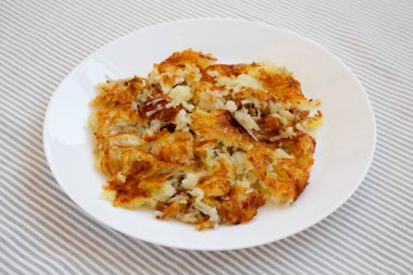 Beyaz bir tabakta ev yapımı kızarmış Hashbrowns. Yakın plan..