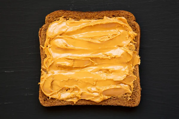 Кусок Хлеба Арахисовым Маслом Черном Фоне Вид Сбоку — стоковое фото