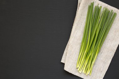 Siyah arka planda çiğ yeşil soğan, üst manzara. Dümdüz, tepeden, yukarıdan. Metin için boşluk.