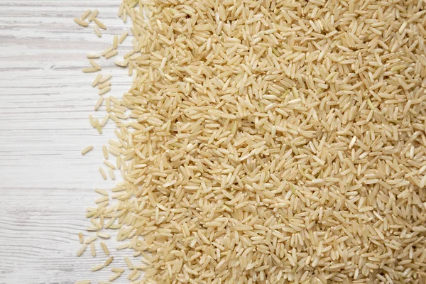 Suché Brown Rice Bílém Dřevěném Pozadí Horní Pohled Nad Hlavou — Stock fotografie