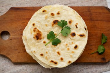 Ev yapımı Roti Chapati tahta üzerinde düz ekmek, üst manzara. Yukarıdan, dümdüz uzanmış.