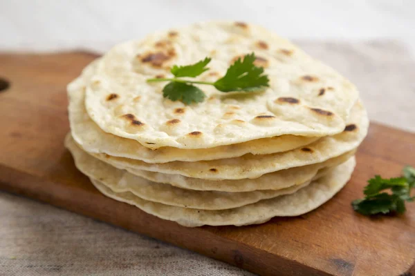 Ev yapımı Roti Chapati yassı ekmeği. Köy tahtasında, yan manzaralı. Yakın plan..