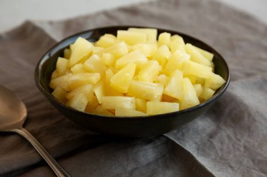 Bir kasede konserve Ananas Tidbit Parçacıkları, yan görünüm. 