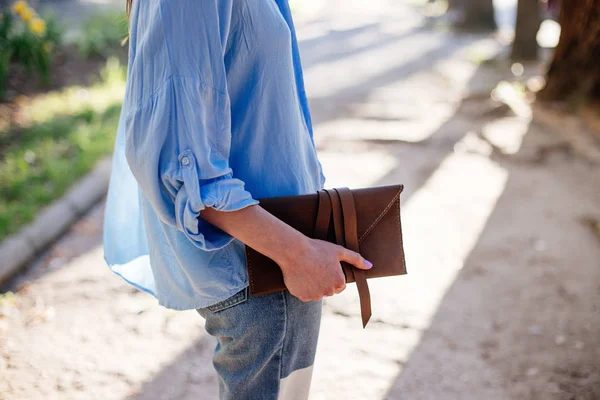 Kız bir debriyaj çanta tutuyor.