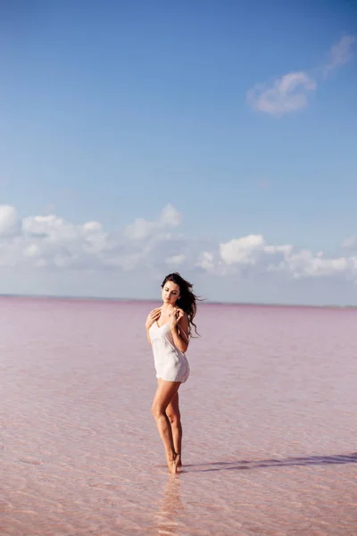 Menina bonita em um lago rosa . — Fotografia de Stock