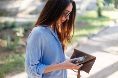 Kız bir debriyaj çanta tutuyor.