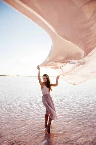 Hermosa chica en un lago rosa . —  Fotos de Stock