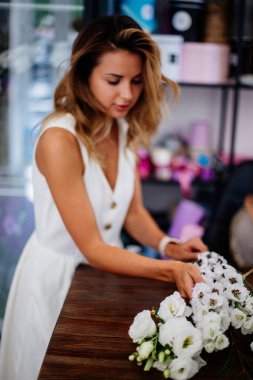 Çiçekçi bir buket yapar.