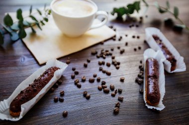 Kapuçino, eklerleri ve çiçekler.