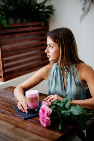 El color latte en el vaso a las muchachas por la mano . — Foto de Stock