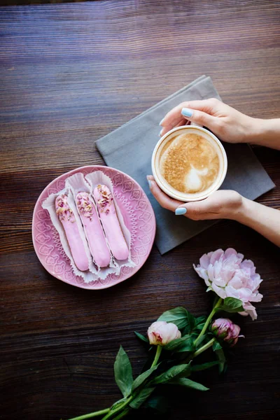 Cappuccino, eclairs y flores . — Foto de Stock