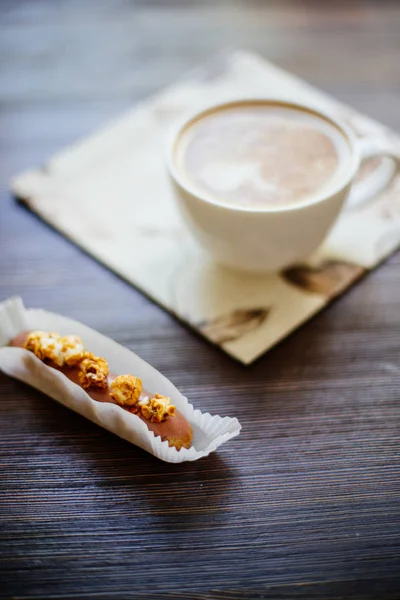 Fincan kapuçino ve bir pasta.