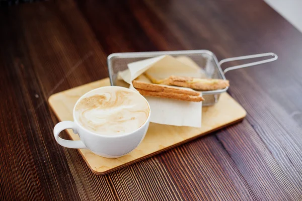 Copa de capuchino y un sándwich . — Foto de Stock