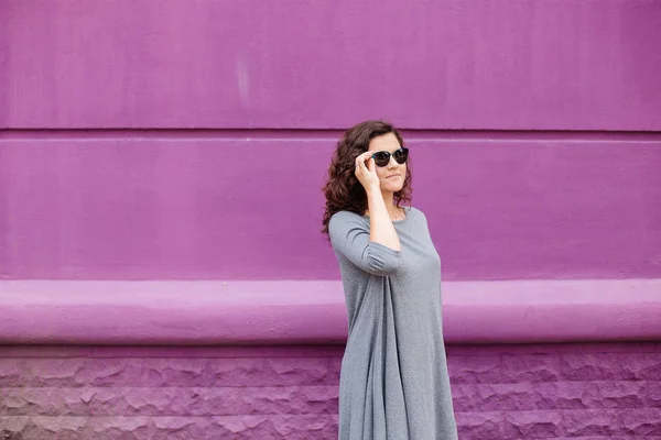 Chica con gafas en una pared púrpura — Foto de Stock
