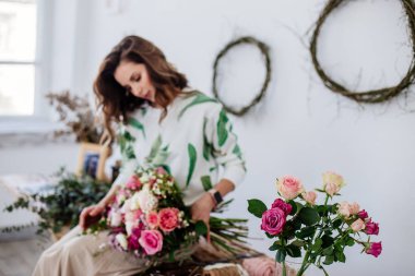 Çiçekçi bir buket yapar.