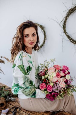 Çiçekçi bir buket yapar.