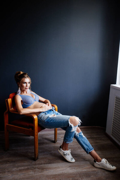 Beautiful pregnant young woman near the wall.