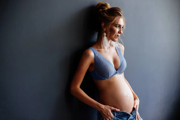 Mooie zwangere jonge vrouw in de buurt van de muur. — Stockfoto