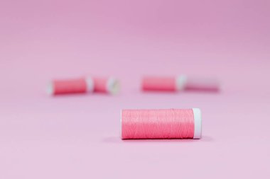 Dikiş iplikleri, pembe arka planda pembe iplik makaraları. Kopya için yer. 