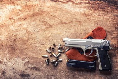 9 mm tabanca tabanca mermi ve şarjör ahşap arka plan üst görünümü üzerine serpiştirilmiş